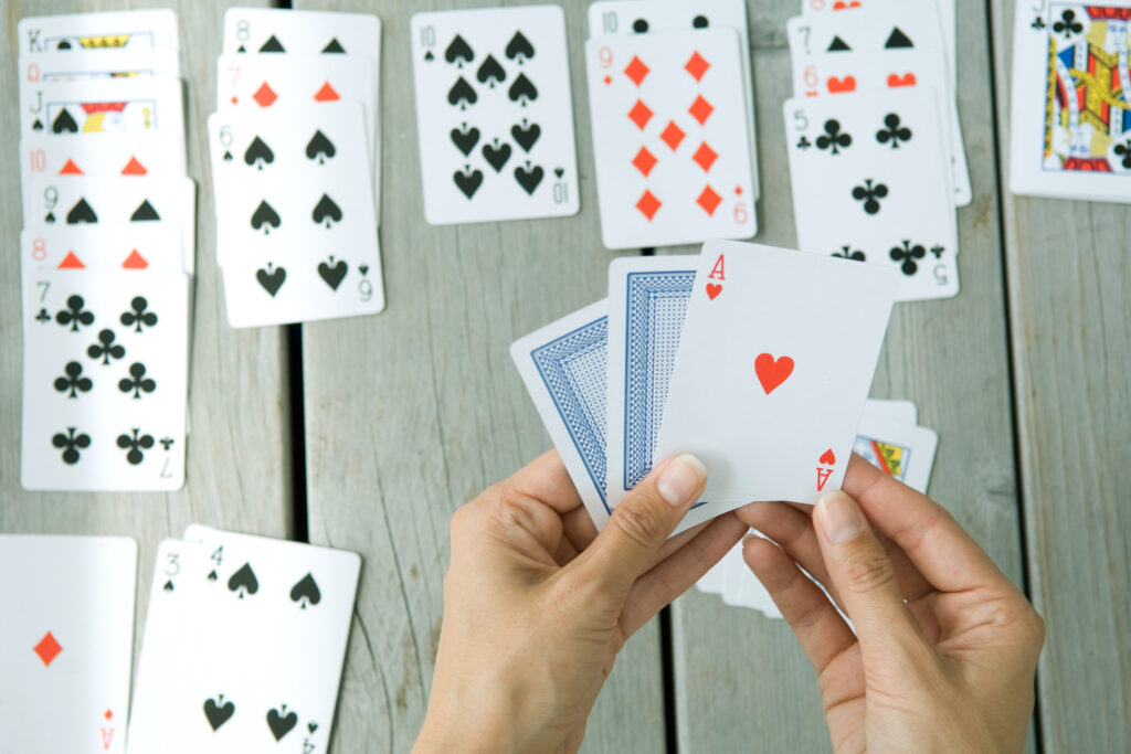 Woman playing card game, cropped view of hands